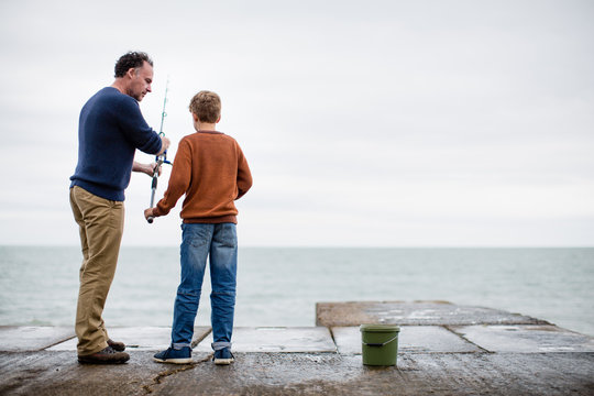 Father passing Son fishing rod