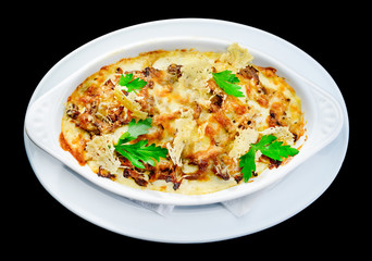 Tasting and appetizing traditional Italian lasagna dish with mushrooms served with fresh dill in a white plate isolated on black background. Autumn menu in an Italian restaurant