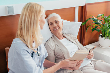 nurse and senior patient with book