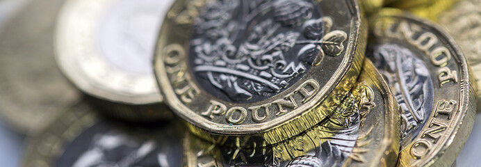 Selective Focus of the New UK One Pound Coin in panoramic format - obrazy, fototapety, plakaty