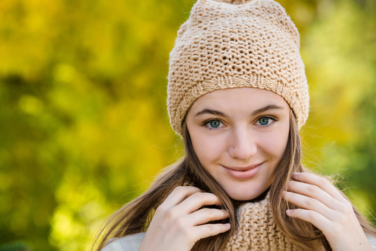 young woman portrait in beige knitted hat outdoor