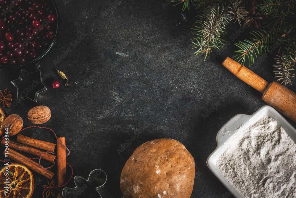 Wall mural Ingredients for Christmas, winter baking cookies. Gingerbread, fruitcake. Flour, cranberries, dried oranges, cinnamon, spices on a black stone table, top view copy space