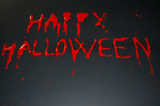 Happy halloween red words on black background. Happy Halloween text with paint or spray. Halloween inscription. Banner.
