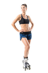 Confident proud fit sporty woman in inline roller skates looking up over the shoulder. Full body...