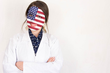 Cheerful  doctor woman with crossed hands and USA flag painted on her face