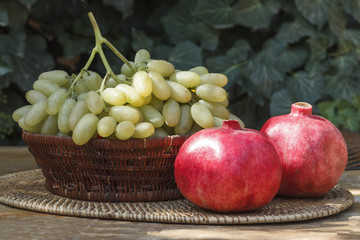 grapes, pomegranate against a background of green ivy