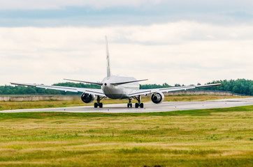 Fototapeta na wymiar Passenger plane jet taxiing along the runway.