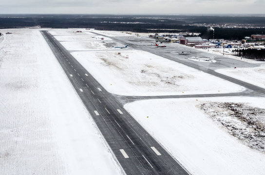 Airport and winter runway, view from a height to a snow-covered landscape.