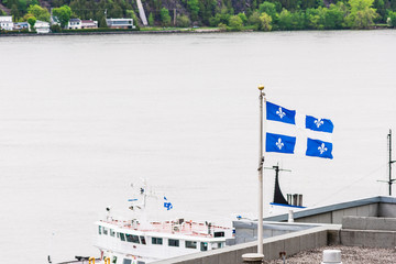 Blue Quebec flag on rooftop with view of boat ship on Saint Lawrence River