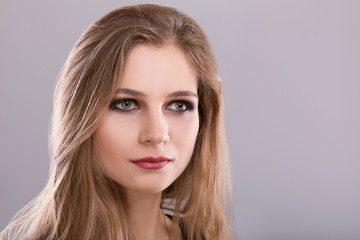Fototapeta premium Portrait of Beautiful woman with make-up on a gray background