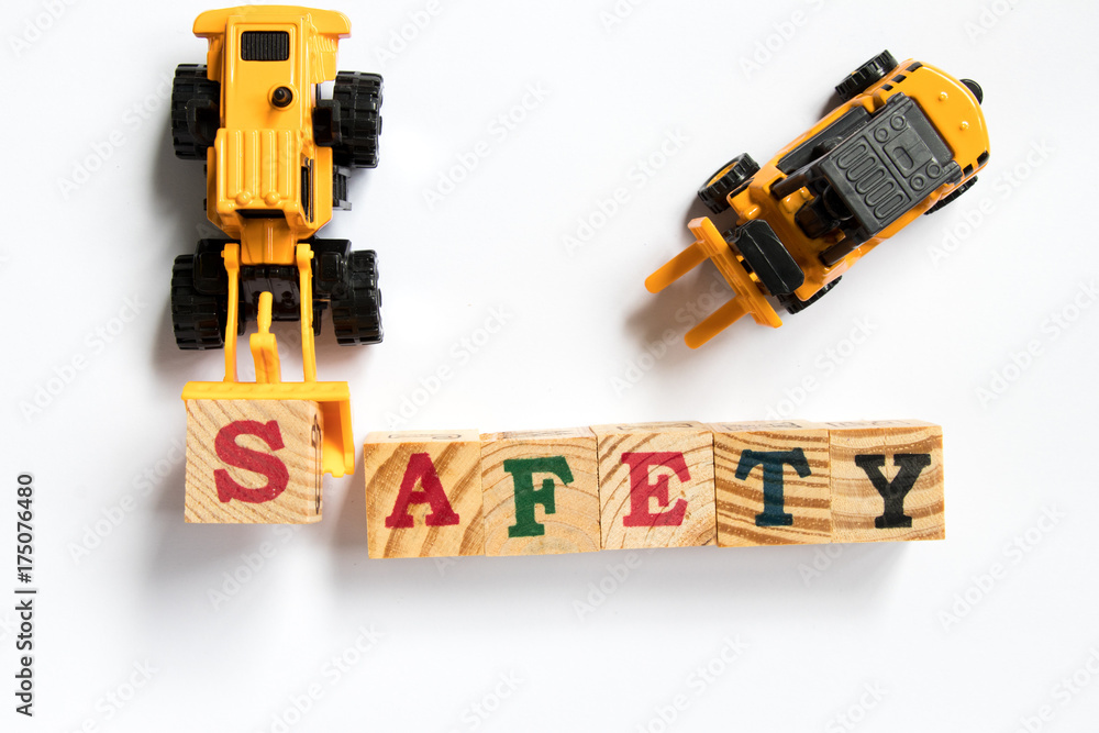 Poster Toy plastic bulldozer hold toy block letter s to fulfill word safety with foklift on white background