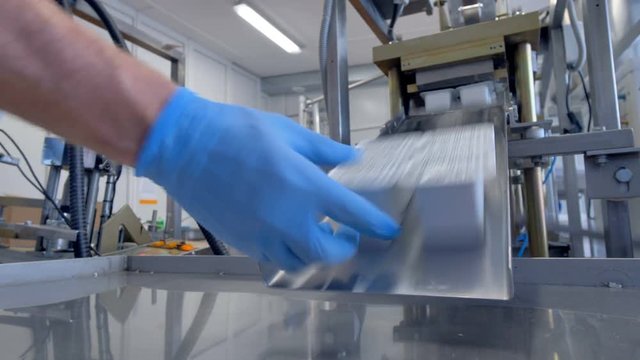 Gloved hands receive ready four-packs with dairy products. Timelapse.