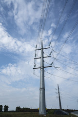 high voltage trellis with clouds in the sky in the background	