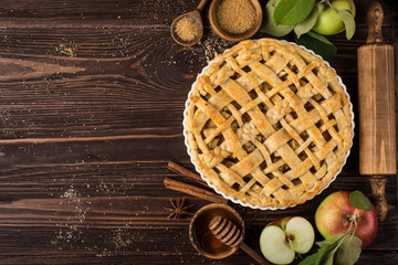 apple pies and ingredients on wooden background.  Top view