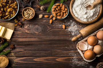 Christmas food background. Baking Ingredients ( fluor, eggs, butter, nuts, sugar, dried fruits) on wooden table. top view. Copy space