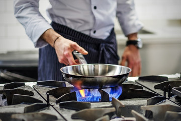 Obraz na płótnie Canvas Chef controls the cooking process