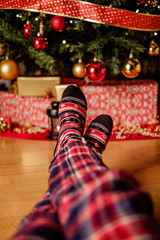 Female legs in front of christmas tree