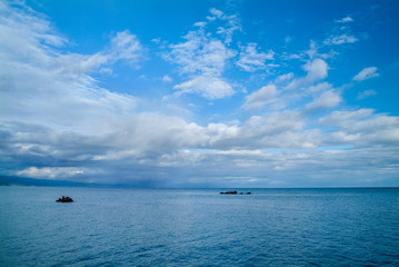 Calm morning sea landscape with cloudy sky and rocks. wide angle. Horizontal frame