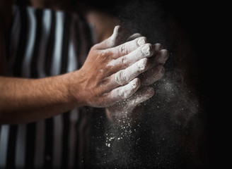 The man cook prepares flour products and meal-free flour on a glass table. Beautiful conceptual photo