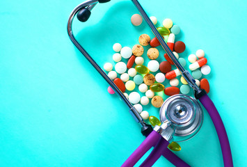 medical stethoscope with pills on a blue background