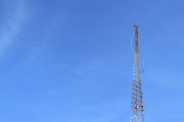 Antenna tower at blue sky and white clouds on a beautiful day.