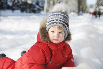 Fototapeta na wymiar Portrait of a child in winter clothes, a walk through a winter park,
