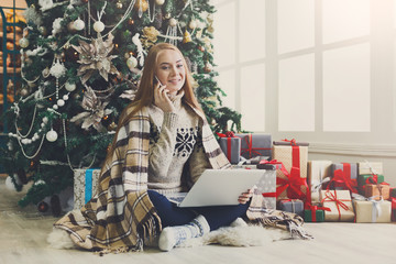Young woman shopping online in cozy christmas interior