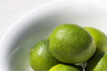 Fresh green Limes in a white bowl 
