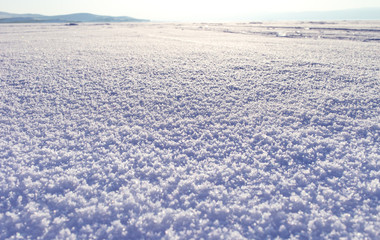 Winter landscape. Snow field sparkling in the sun, surface snow texture. Christmas natural background. Lake Baikal