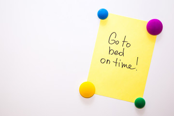 Fridge note with the text about wellness: Go to bed on time!
