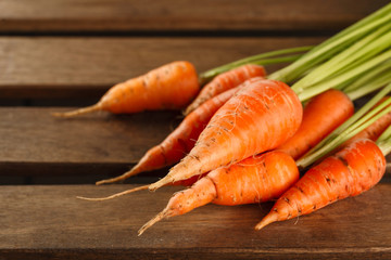 Fresh carrots on wooden background