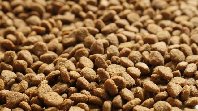 Close-up pile of cat or dog pellet meal footage - Brown pet dry food slow tilt video