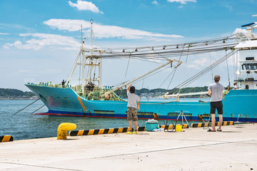 Fototapeta na wymiar 釣り人と停泊する遠洋漁船