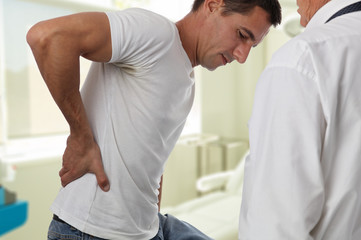 Muscular Man suffering from back and neck pain. Incorrect sitting posture problems Muscle spasm,...