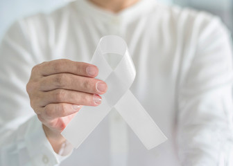 White ribbon or light pearl bow color symbolic for raising awareness on Lung cancer, bone cancer, Multiple Sclerosis, and symbol for international day of non-violence against women