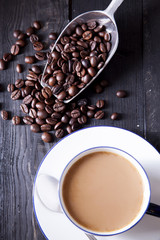 Coffee beans and sweet coffee on black wood table