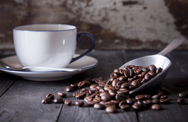 Coffee in metal dipper and white coffee cup