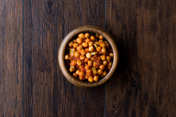 Bowl of Chana Masala Chickpeas on dark wooden surface.
