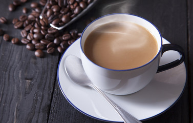 Hot coffee and white coffee cup on black wood table