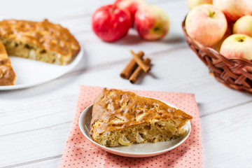 Homemade apple pie with cinnamon and fresh ripe apples in the background