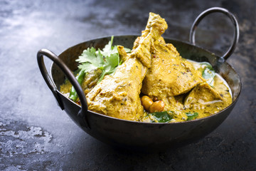 Traditional Indian curry chicken as close-up in a korai