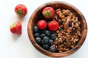Healthy breakfast: homemade gramola with fresh blueberry and strawberry on white background