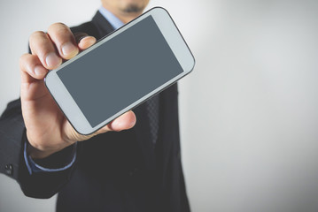 Close-up businessman holding smart phone. Businessman holding device screen mock up.