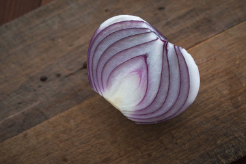 Food preparation, cooking concept: chopped and peeled fresh red onions on rustic wooden background