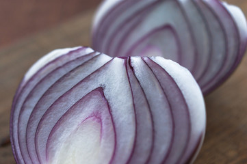 Fototapeta premium Food preparation, cooking concept: chopped and peeled fresh red onions on rustic wooden background