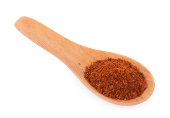 Pile of red paprika powder in wooden spoon isolated
