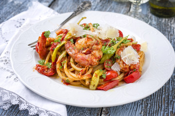 Italian linguine alla gamberetti with vegetable and parmesan as close-op n a plate