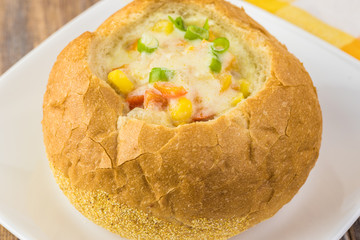 Homemade corn and cheese chowder in bread bowl.