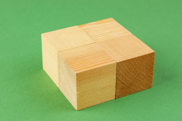 wooden geometric cube on a green background