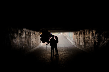 Silhouette of a beautiful young couple in the underpass